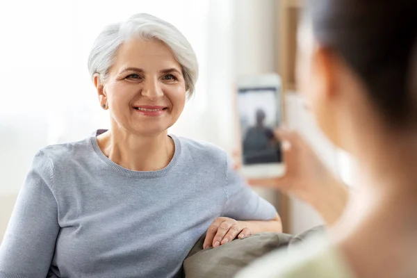 Hija adulta fotografiando a la madre mayor en casa — Foto de Stock