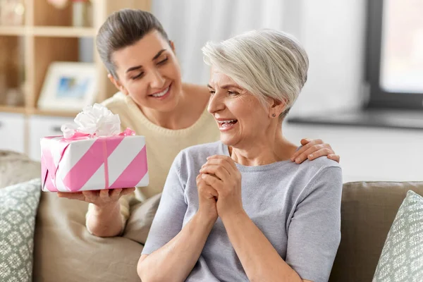 Figlia adulta che fa un regalo alla madre maggiore — Foto Stock