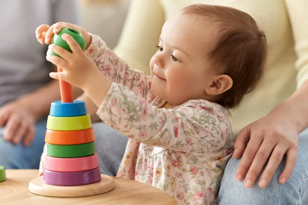 幸せな赤ちゃん女の子遊びとともにおもちゃピラミッドで家 — ストック写真