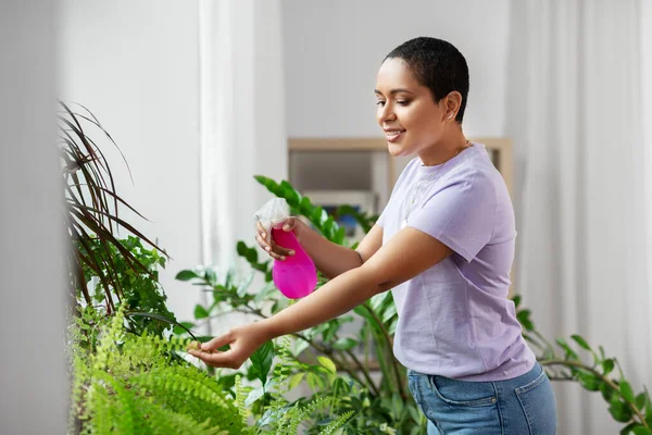 家庭用水喷洒家庭植物的妇女 — 图库照片