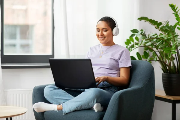 Mujer con portátil escuchando música en casa — Foto de Stock