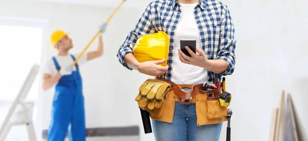 Mulher ou construtor com telefone e ferramentas de trabalho — Fotografia de Stock