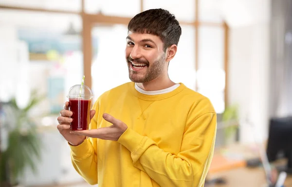 Happy man with juice in plastic cup at office — Stock Photo, Image