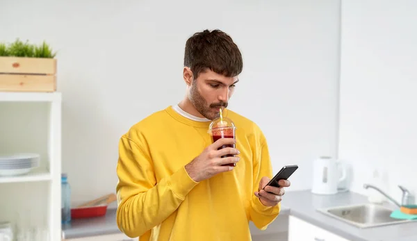 Man med smartphone och tomatjuice — Stockfoto