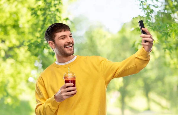 拿着智能手机和果汁自私自利的快乐男人 — 图库照片