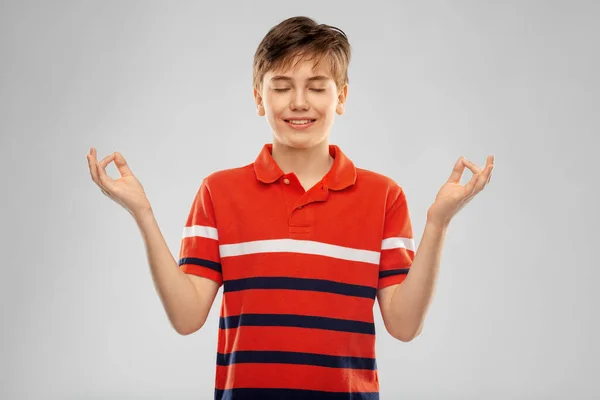 Happy smiling meditating boy in red polo t-shirt — Stock Photo, Image