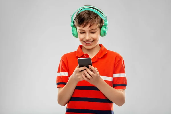 boy in headphones listening to music on smartphone