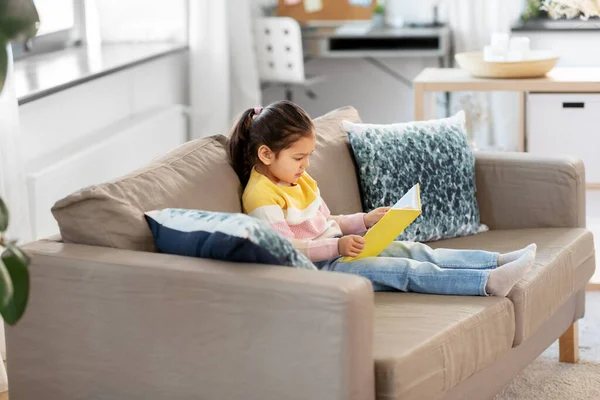 Μικρό κορίτσι διαβάζει βιβλίο στο σπίτι — Φωτογραφία Αρχείου