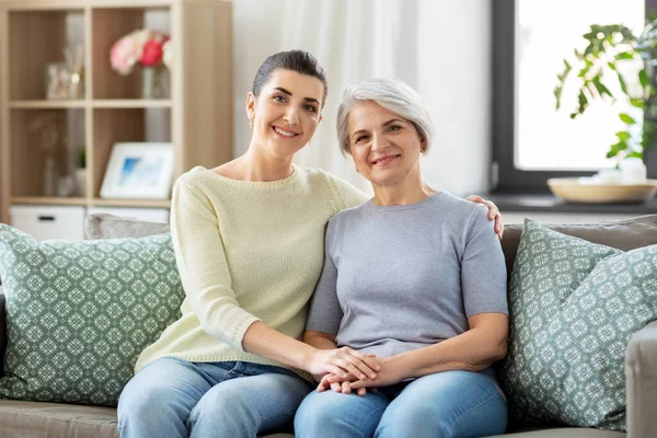 Senior moeder met volwassen dochter knuffelen thuis — Stockfoto