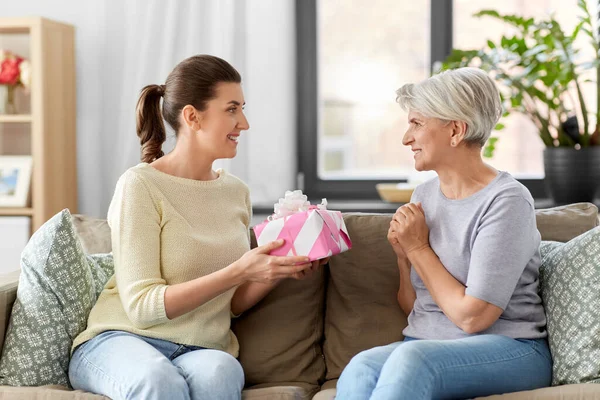 Hija adulta dando regalo a su madre mayor — Foto de Stock