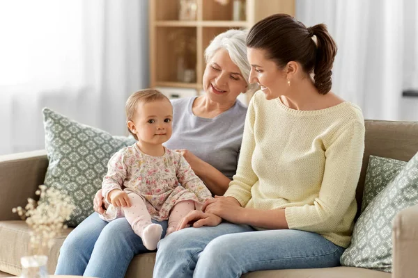 Anya, lánya és nagymamája otthon a kanapén — Stock Fotó