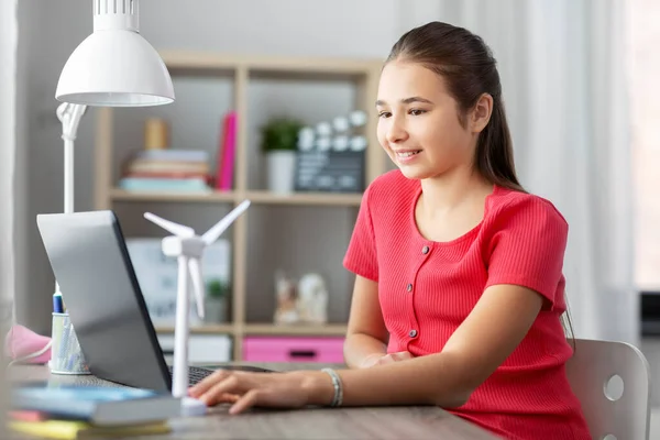 Mädchen mit Laptop und Windkraftspielzeug zu Hause — Stockfoto