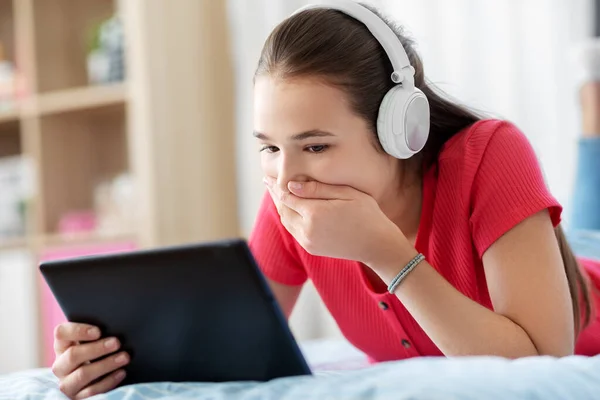 Meisje in hoofdtelefoon luisteren naar muziek op tablet pc — Stockfoto