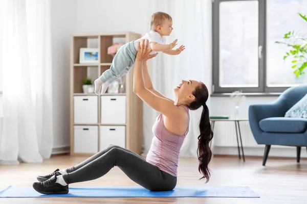 Mãe feliz com pequeno bebê se exercitando em casa — Fotografia de Stock