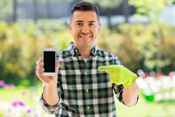 Man van middelbare leeftijd met smartphone in de zomertuin — Stockfoto