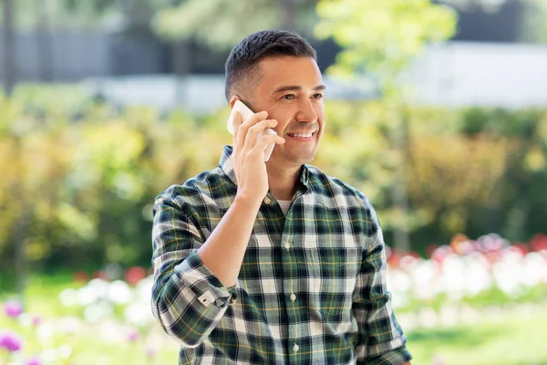 Hombre feliz llamando en el teléfono inteligente en el jardín de verano —  Fotos de Stock