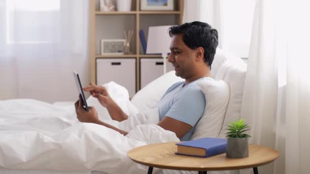 Szczęśliwy Indianin człowiek z tabletem w łóżku w domu — Wideo stockowe