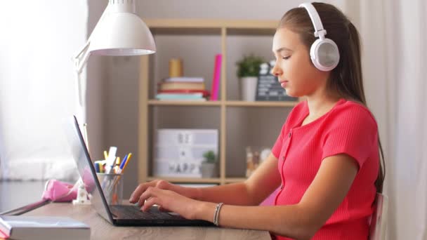 Girl in headphones with laptop computer at home — Stock Video