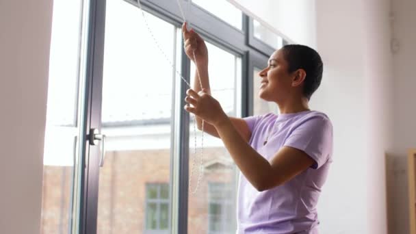 Mujer africana cierra persianas de ventana en casa — Vídeos de Stock