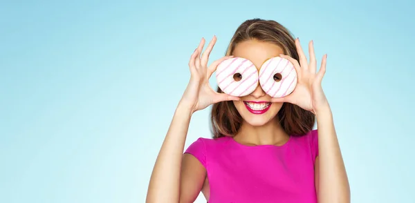 Mujer feliz o chica adolescente mirando a través de donuts —  Fotos de Stock