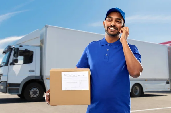 Homem de entrega indiano com smartphone e caixa de encomendas — Fotografia de Stock