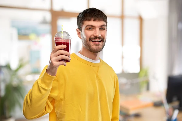 办公室里拿着塑料杯子里的果汁的快乐男人 — 图库照片