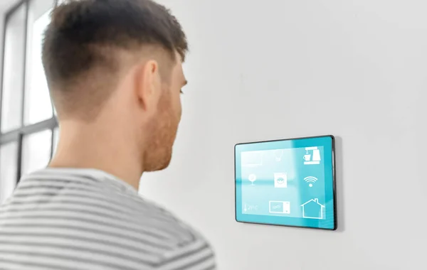 Чоловік дивиться на планшетний комп'ютер у розумному будинку — стокове фото