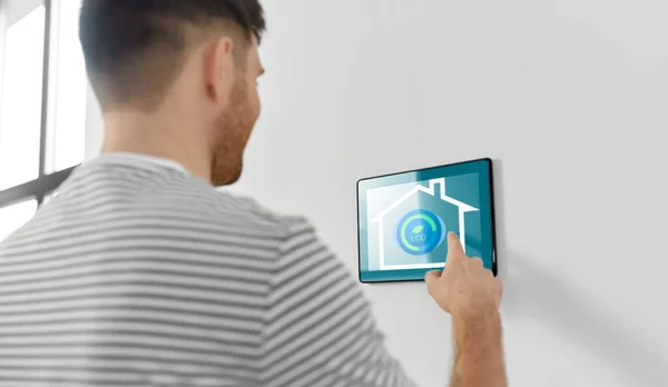Uomo guardando tablet computer a casa intelligente — Foto Stock