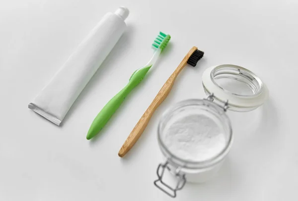 Toothbrushes, toothpaste and soda in jar — Stock Photo, Image