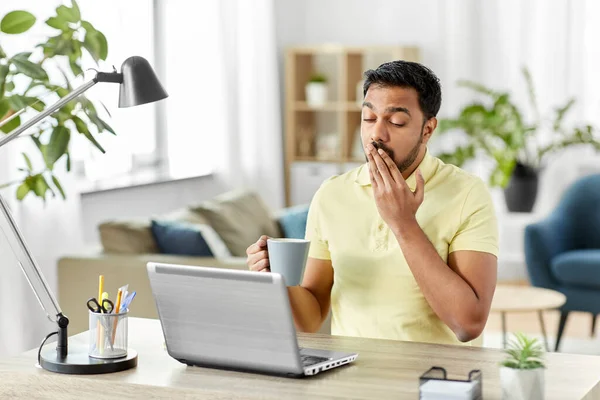 Pria dengan laptop dan kopi menguap di kantor rumah — Stok Foto