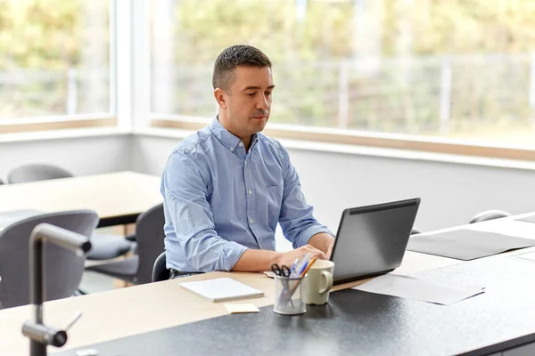 Hombre con el ordenador portátil que trabaja en casa oficina — Foto de Stock