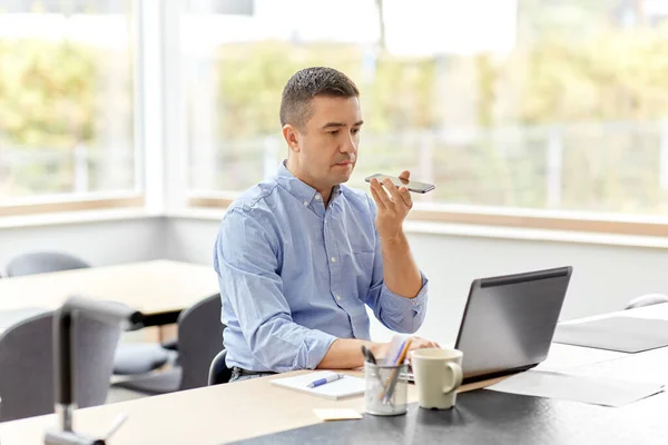 Homme avec smartphone et ordinateur portable au bureau à domicile — Photo