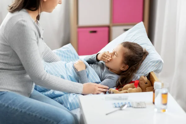 Mutter und kranke kleine Tochter zu Hause im Bett — Stockfoto