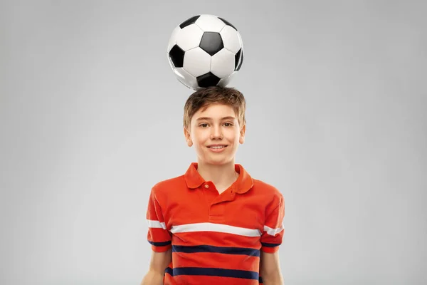 Χαρούμενο χαμογελαστό αγόρι με μπάλα ποδοσφαίρου στο κεφάλι του — Φωτογραφία Αρχείου