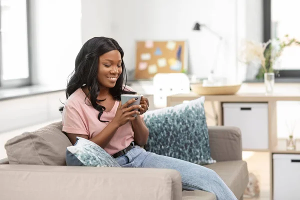 Boldog afrikai nő iszik teát vagy kávét otthon — Stock Fotó
