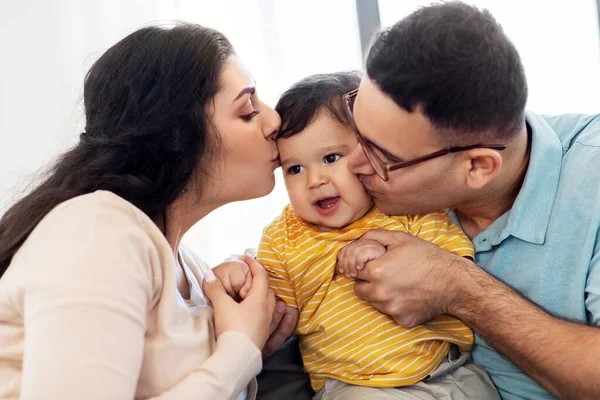 Feliz madre y padre besos bebé hijo en casa — Foto de Stock