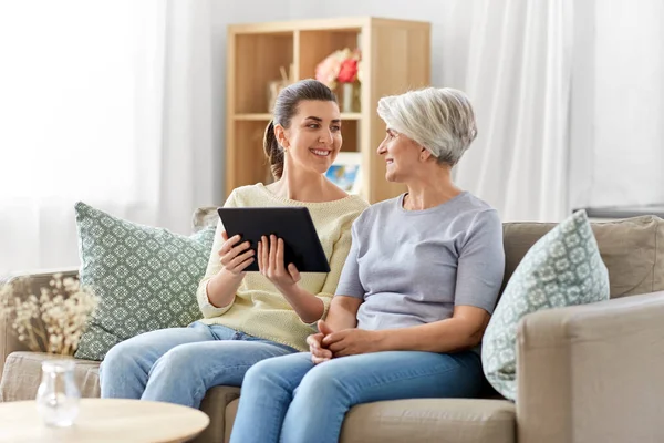 Figlia e madre anziana con tablet pc a casa — Foto Stock