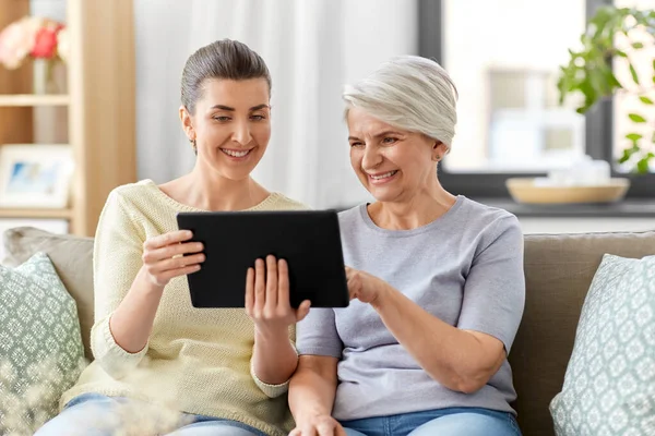 Dochter en senior moeder met tablet pc thuis — Stockfoto