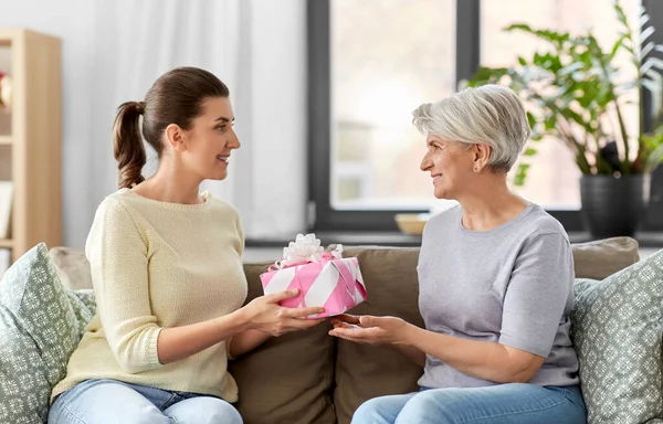 Volwassen dochter geven cadeau aan haar senior moeder — Stockfoto