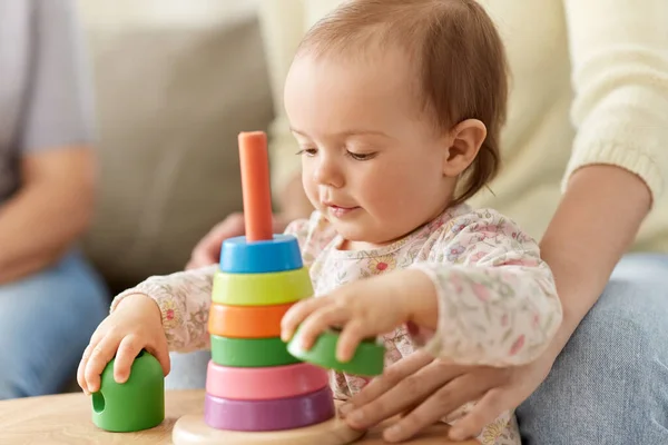 Schönes kleines Mädchen spielt zu Hause mit Spielzeugpyramide — Stockfoto