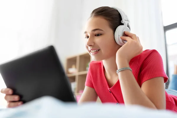 Chica en auriculares escuchando música en la tableta de la PC —  Fotos de Stock