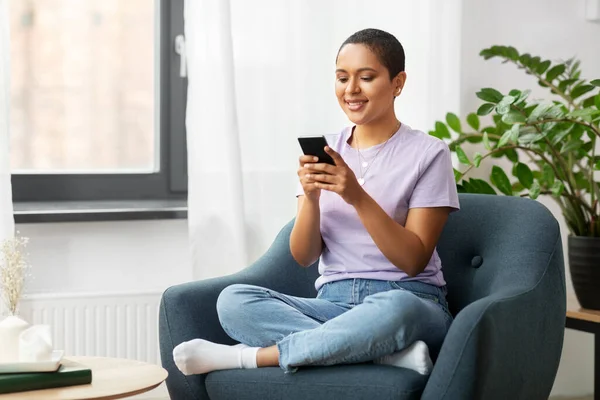 Mulher americana africana com smartphone em casa — Fotografia de Stock