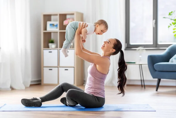 小さな赤ちゃんが家で運動している幸せな母親は — ストック写真