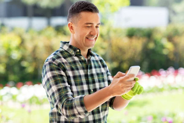Szczęśliwy człowiek ze smartfonem w ogrodzie letnim — Zdjęcie stockowe