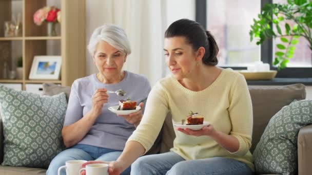 Alte Mutter und erwachsene Tochter essen Kuchen zu Hause — Stockvideo