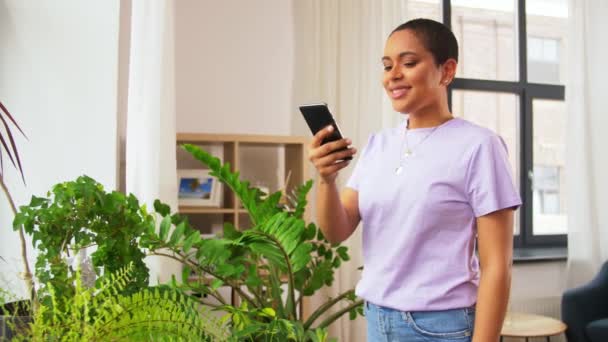 African american woman with smartphone at home — Stock Video