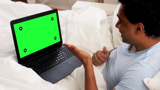 Glücklicher Mann mit Laptop im Bett mit Videoanruf — Stockvideo