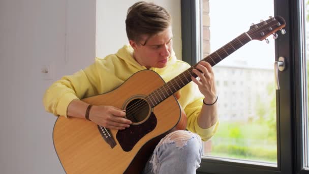 Giovane sintonia chitarra seduta sul davanzale della finestra — Video Stock