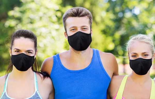 Groep gelukkige vrienden of sporters in het zomerpark — Stockfoto