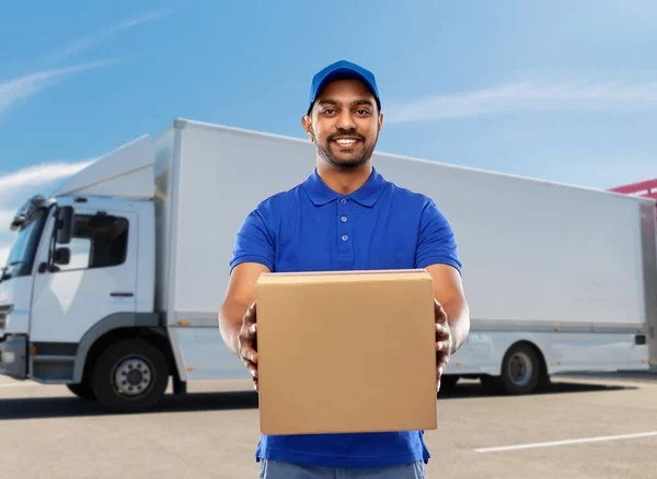 Happy indian delivery man with parcel box in blue — Stock Photo, Image